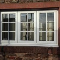 White PVC window - equal glass sizes with central dummy sash and 2 side openers - glazed with face-fix bars